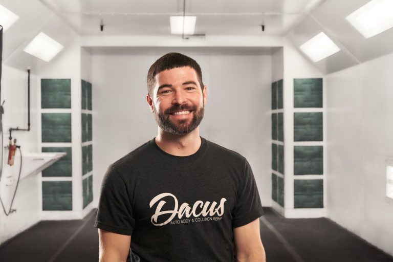 A man wearing a black t-shirt with the word dacus on it