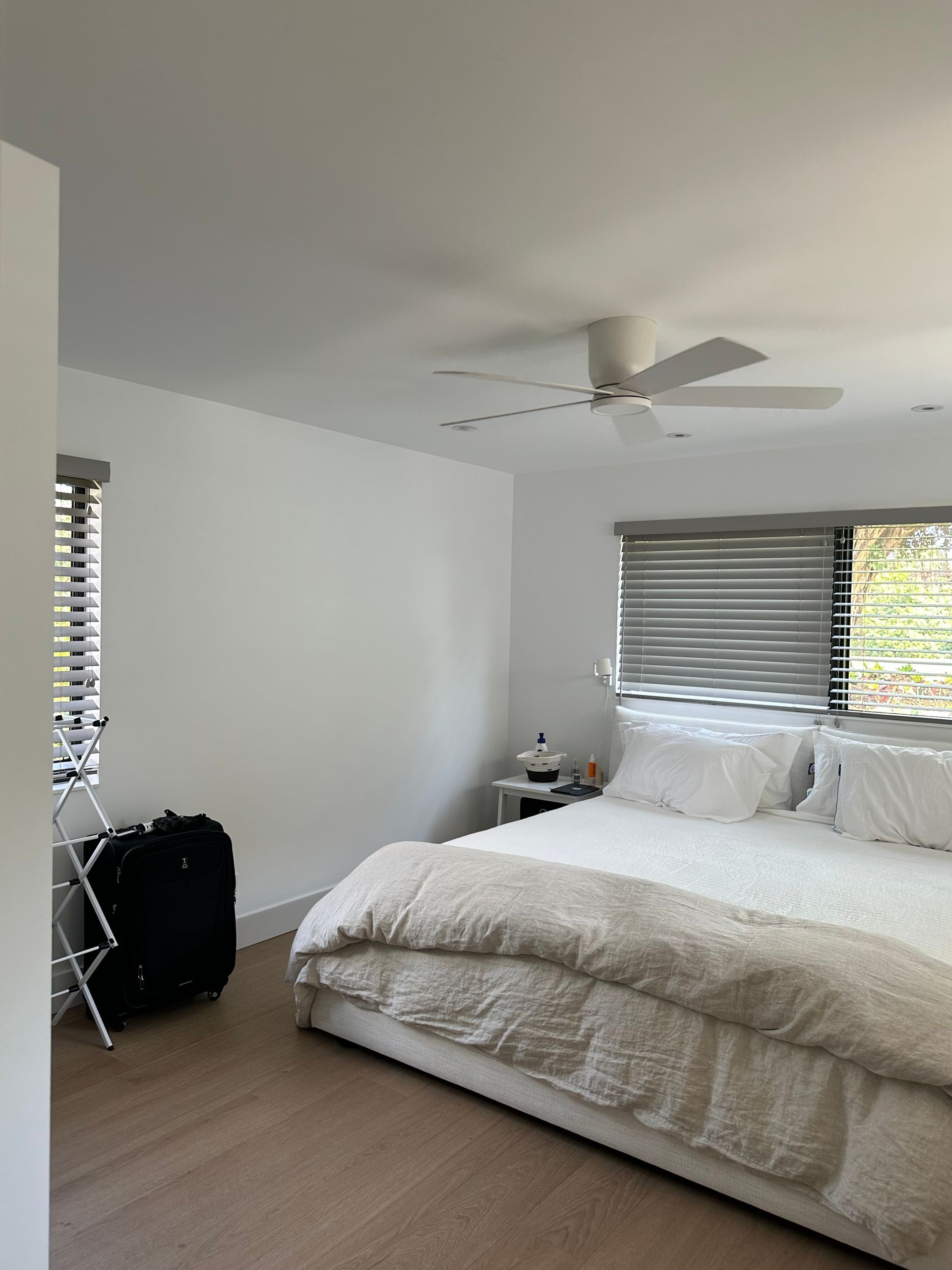 A bedroom with a large bed and a ceiling fan