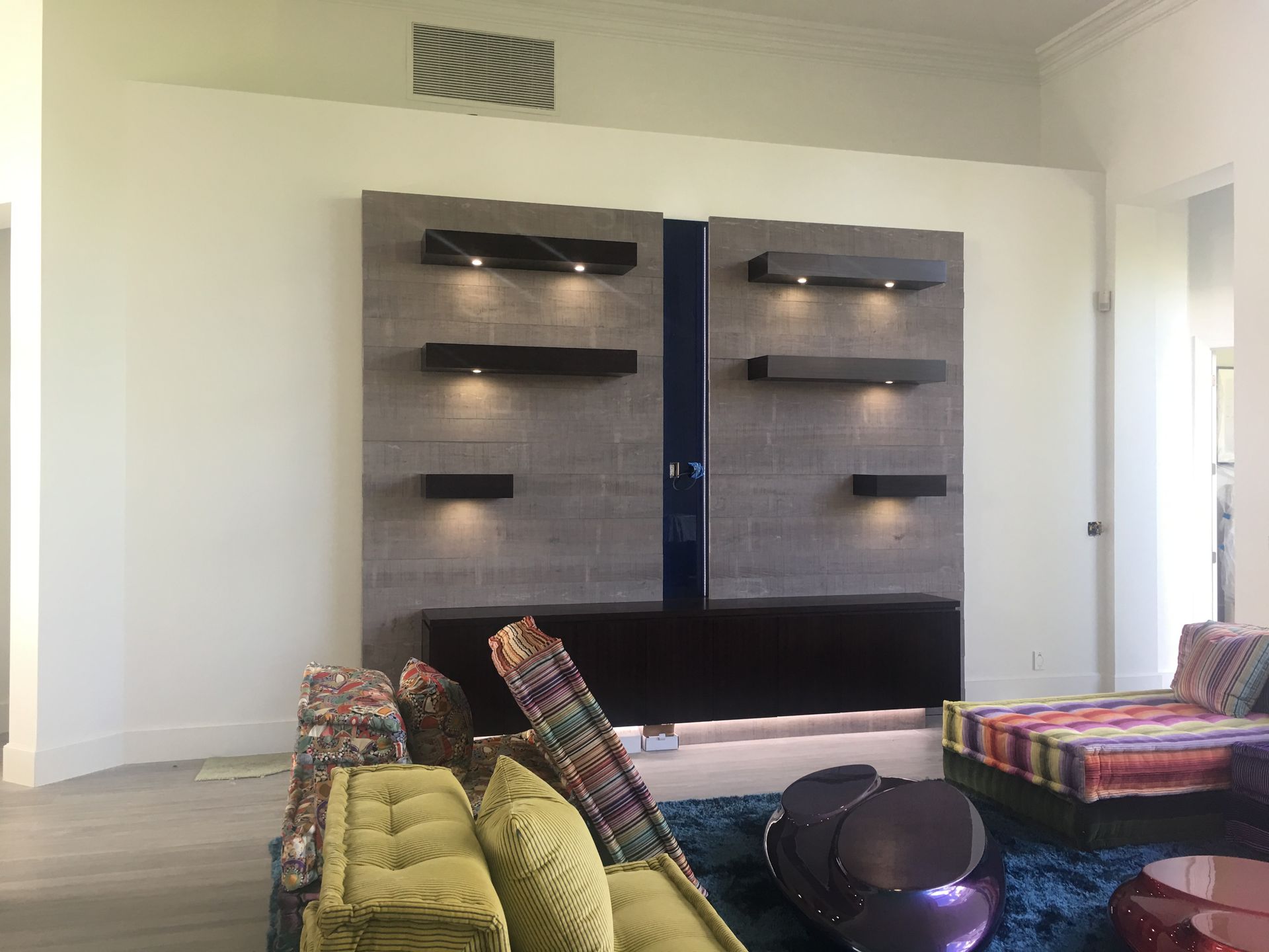 A living room with a couch , chairs and shelves