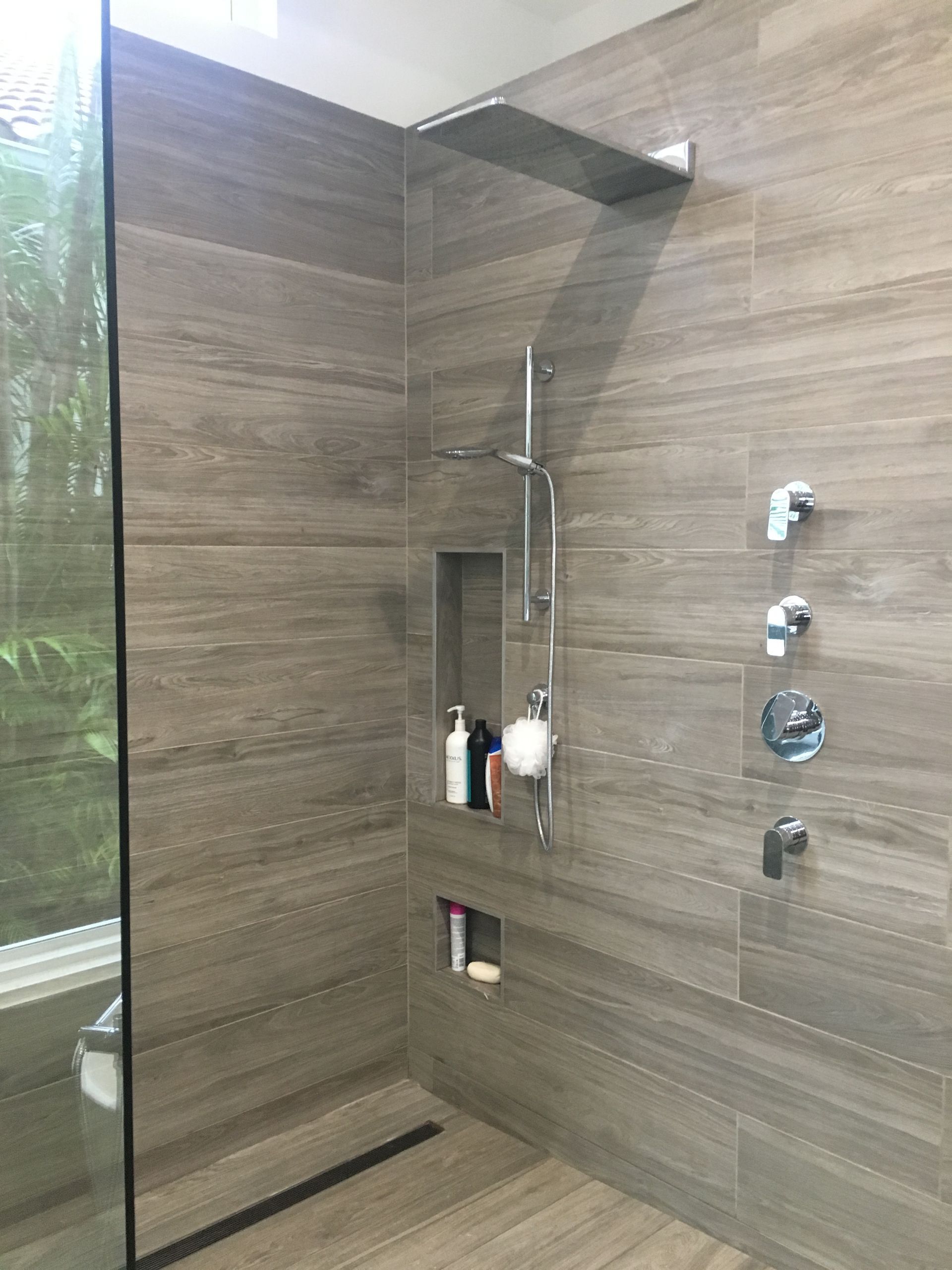 A bathroom with a walk in shower and a glass door.