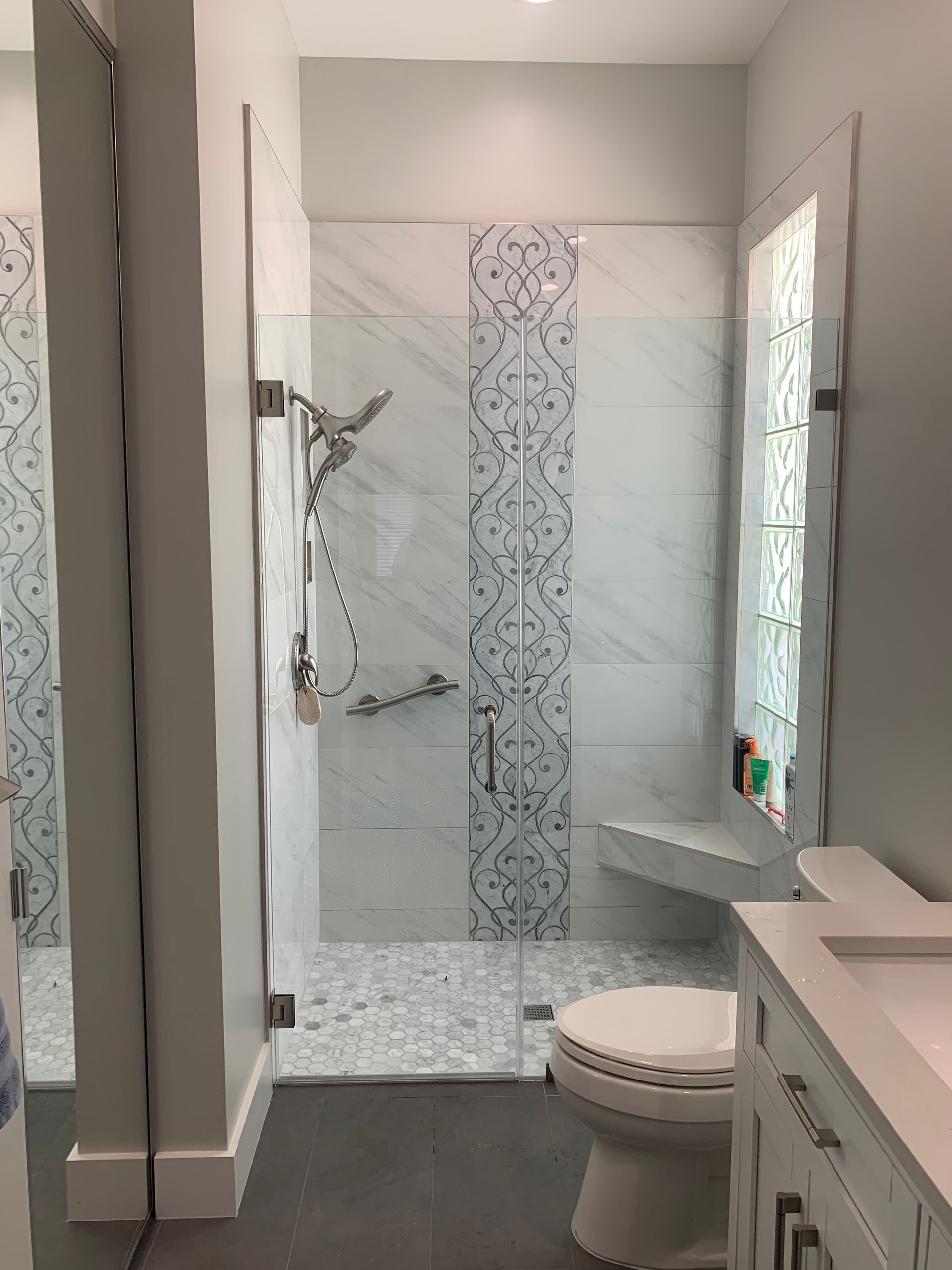 A bathroom with a toilet , sink and shower.