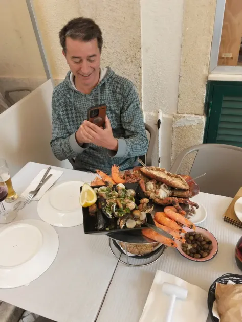 Traveler photographing a Portuguese seafood platter on a private tour