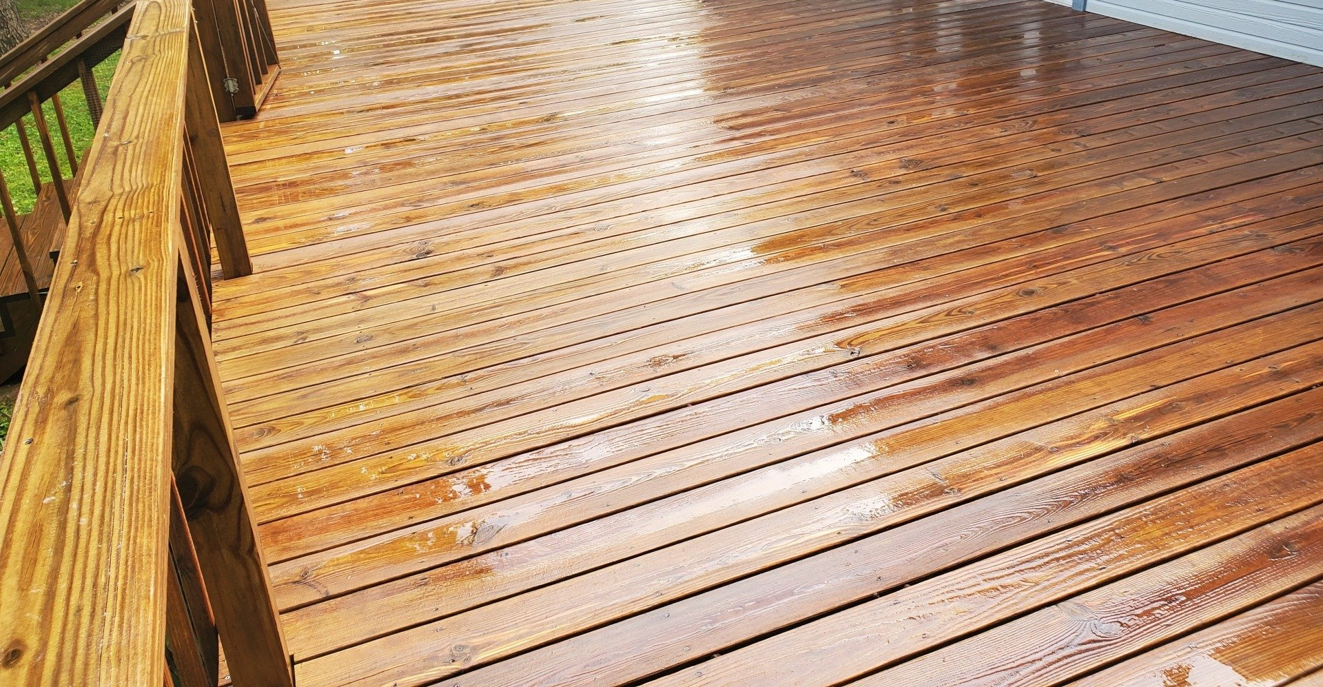 A wooden deck is being cleaned with a pressure washer.