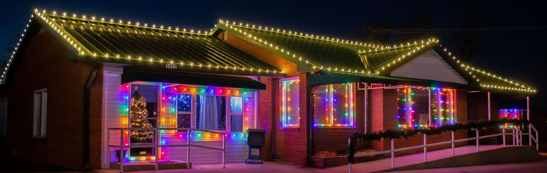 A house is decorated with lots of christmas lights at night.
