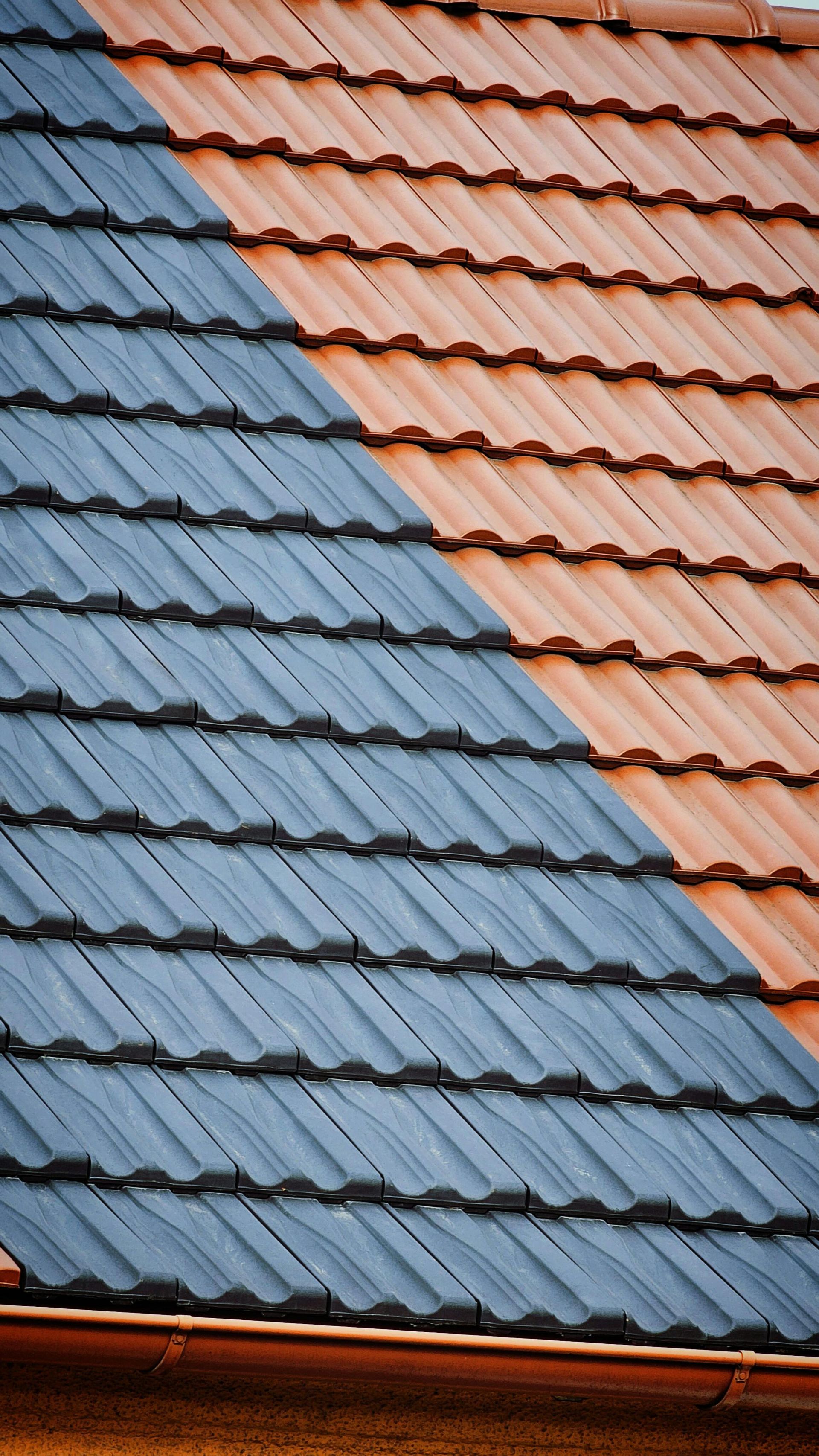 A close up of a roof with two different colored tiles.