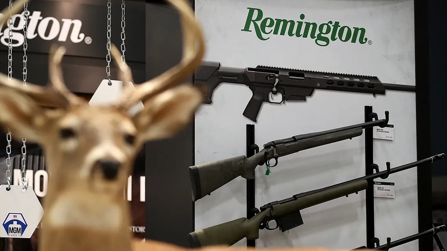 a deer is standing in front of a Remington sign