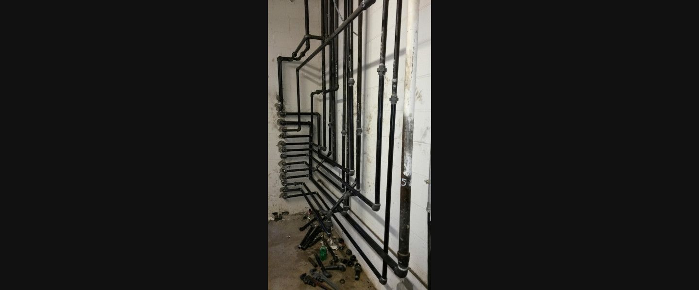A room with a lot of pipes on the wall.