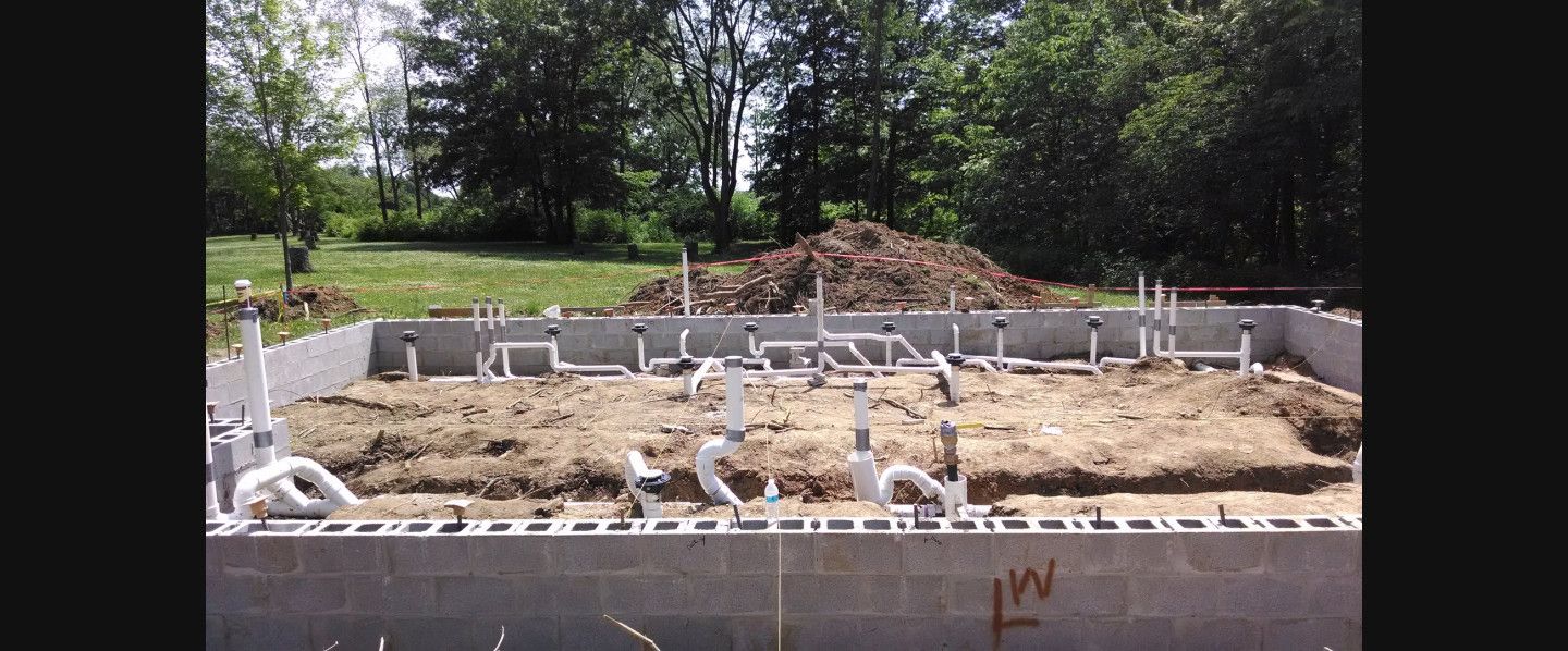 A large pile of dirt is sitting on top of a concrete foundation.