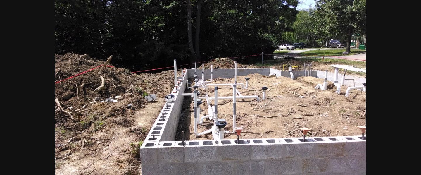 A foundation for a house is being built in a dirt field.