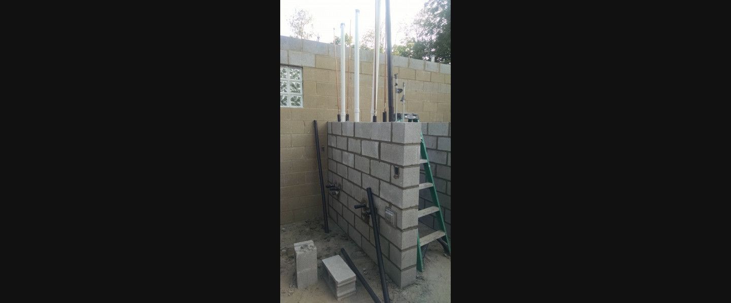 A ladder is sitting next to a wall made of bricks.