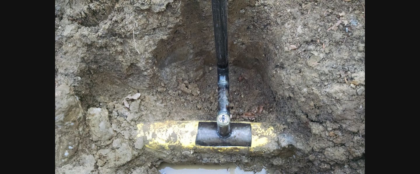 A close up of a pipe in the ground.