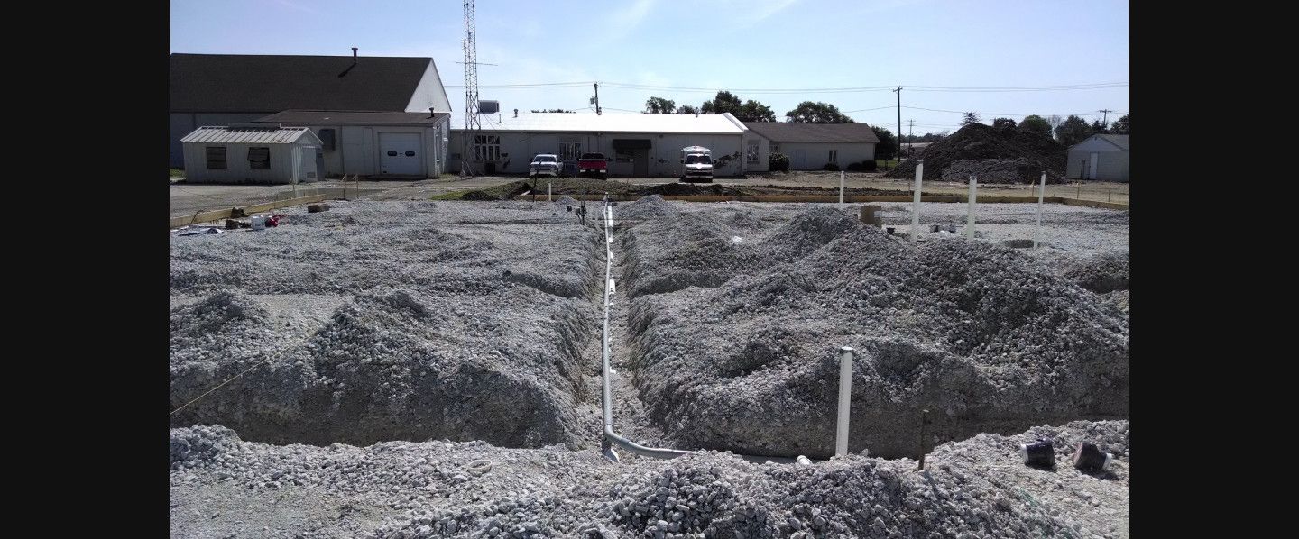 A large pile of gravel with a building in the background