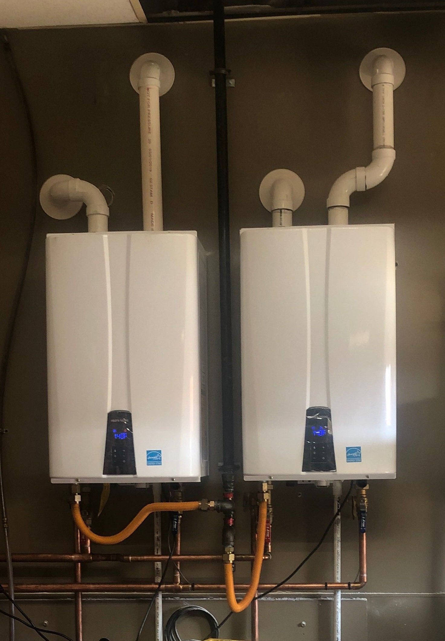 Two water heaters are connected to each other in a room.