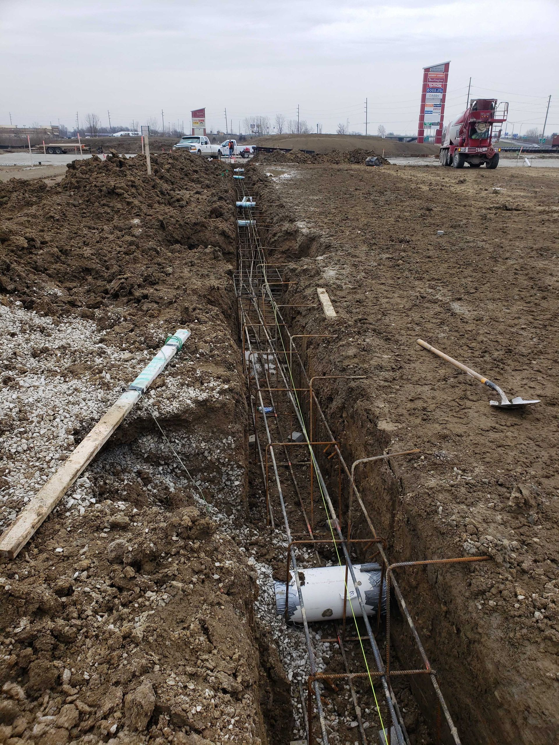 A construction site with a concrete mixer in the background.