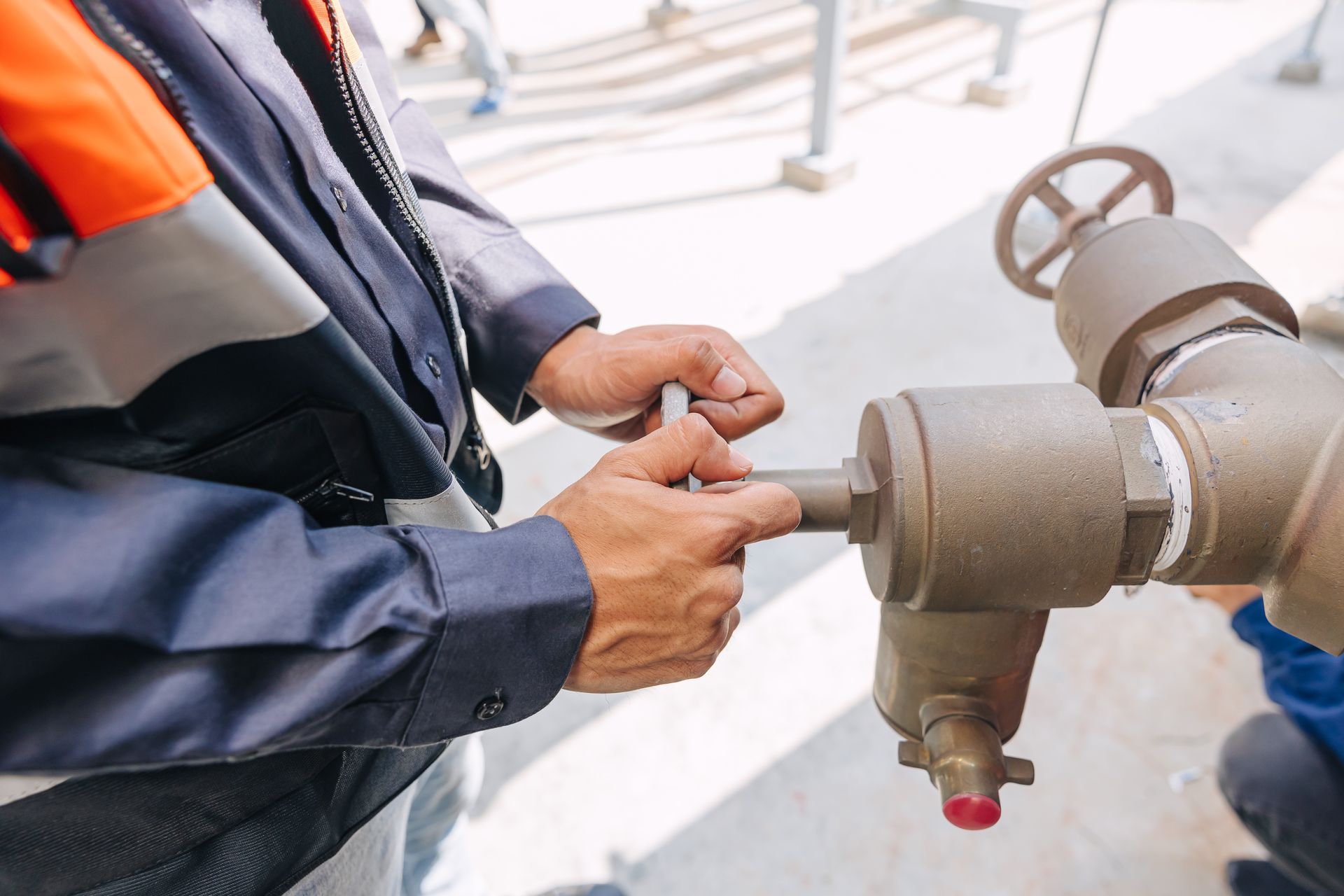 A man is fixing a valve on a pipe.