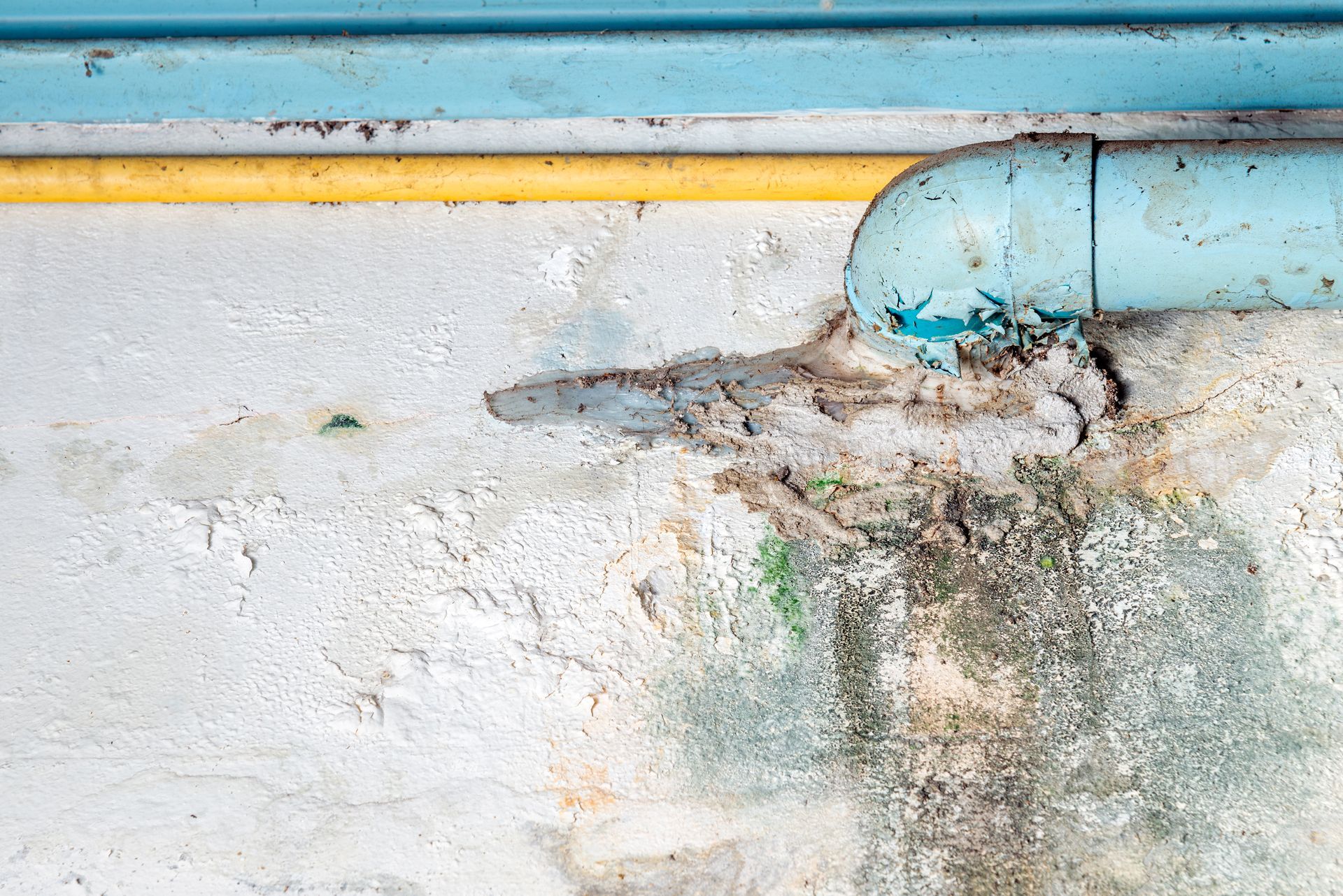 A close up of a pipe on a concrete wall.