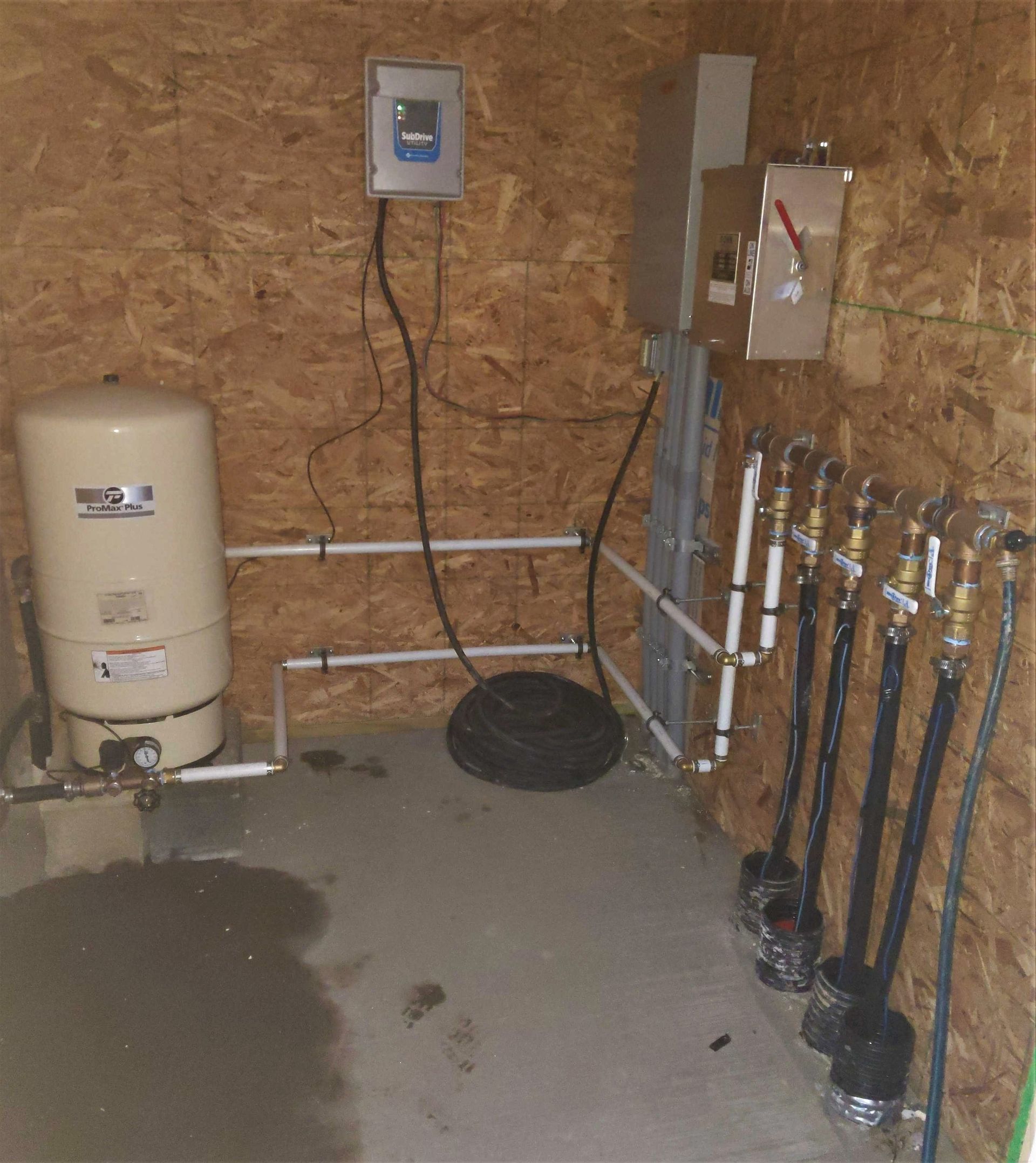 A room with a water tank and a bunch of pipes