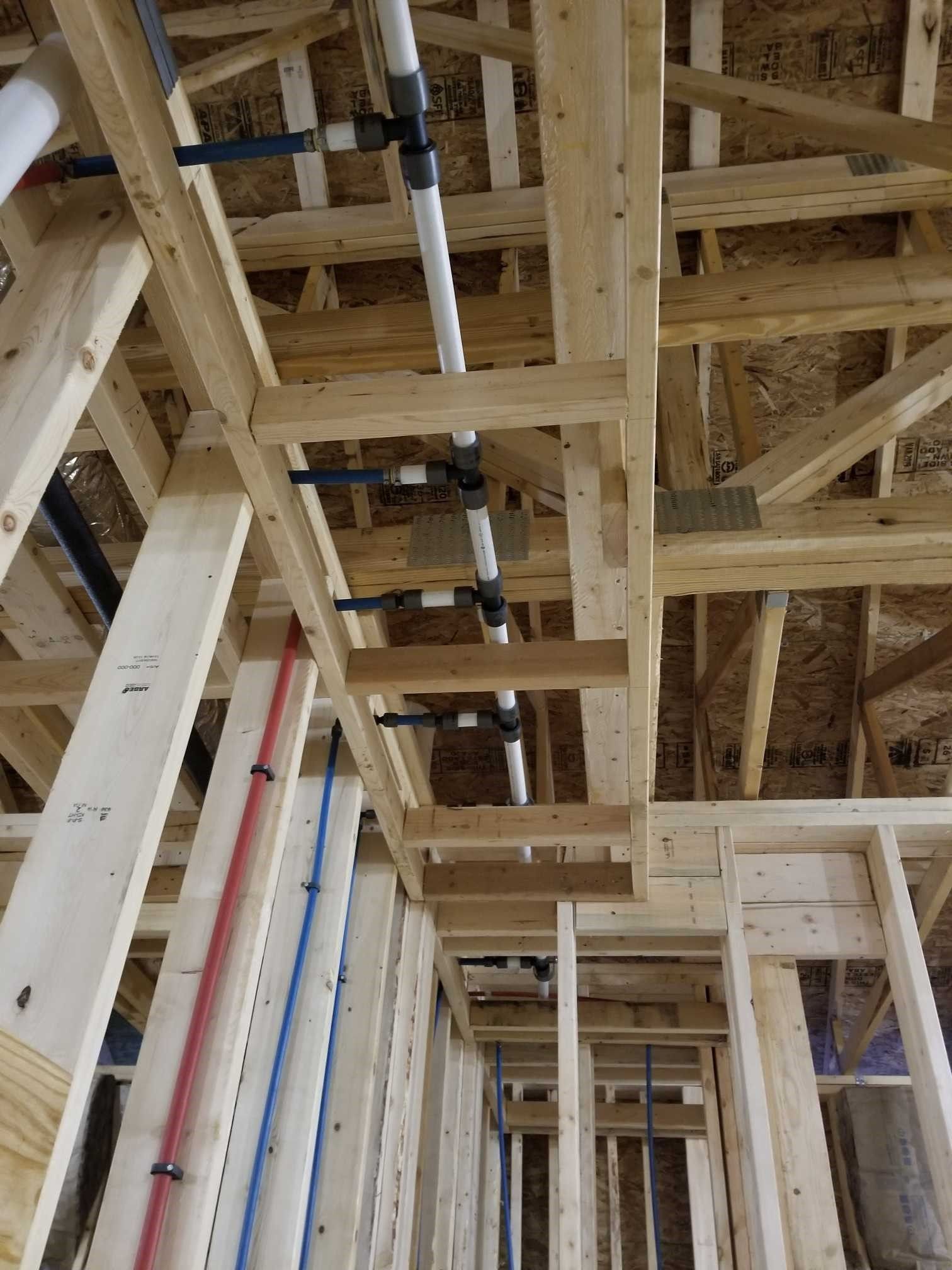A building under construction with pipes hanging from the ceiling