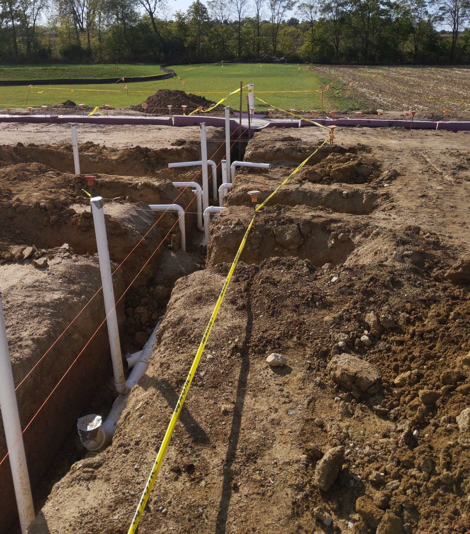 A construction site with a yellow tape measure in the dirt