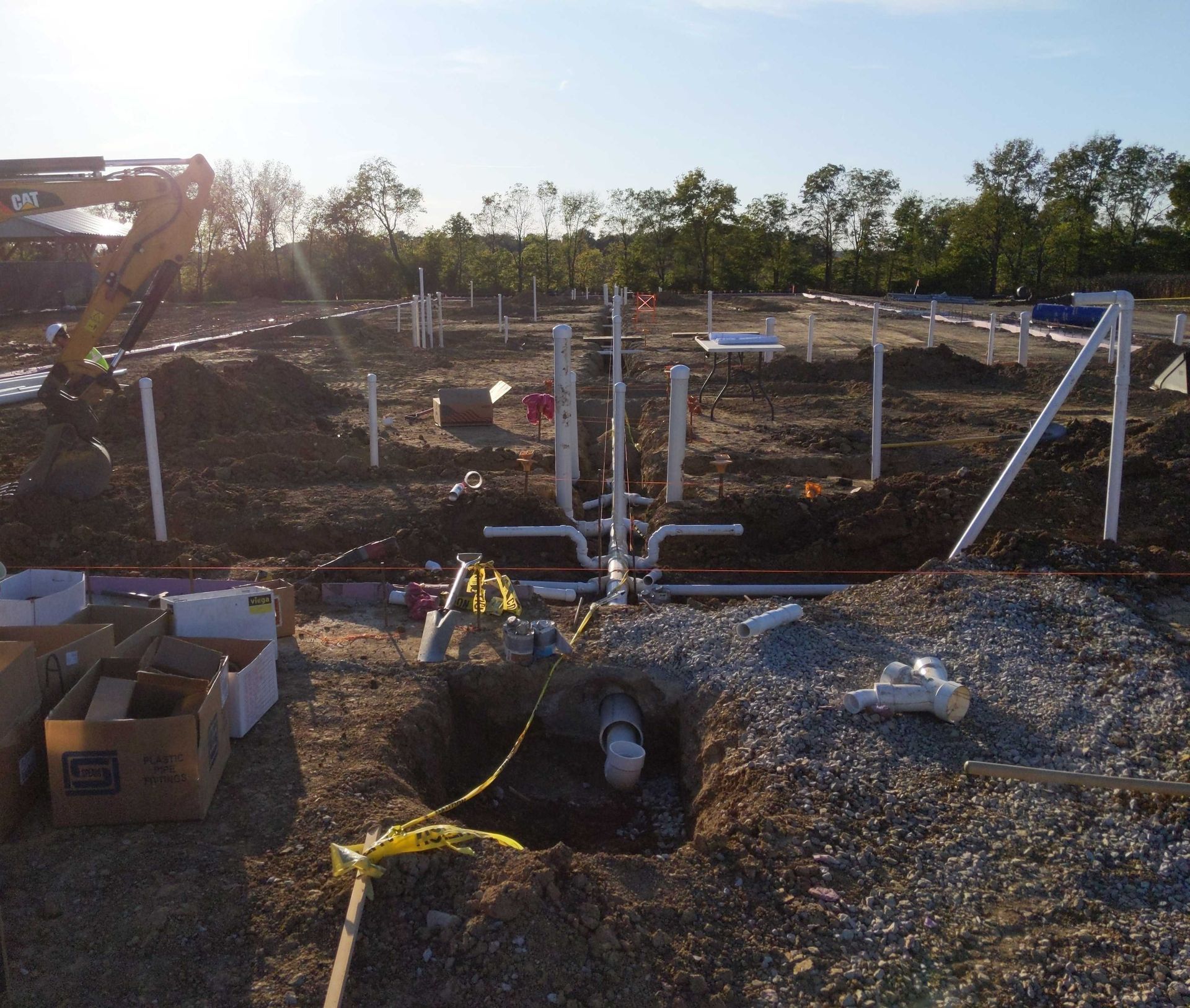 A construction site with pipes and boxes in the dirt