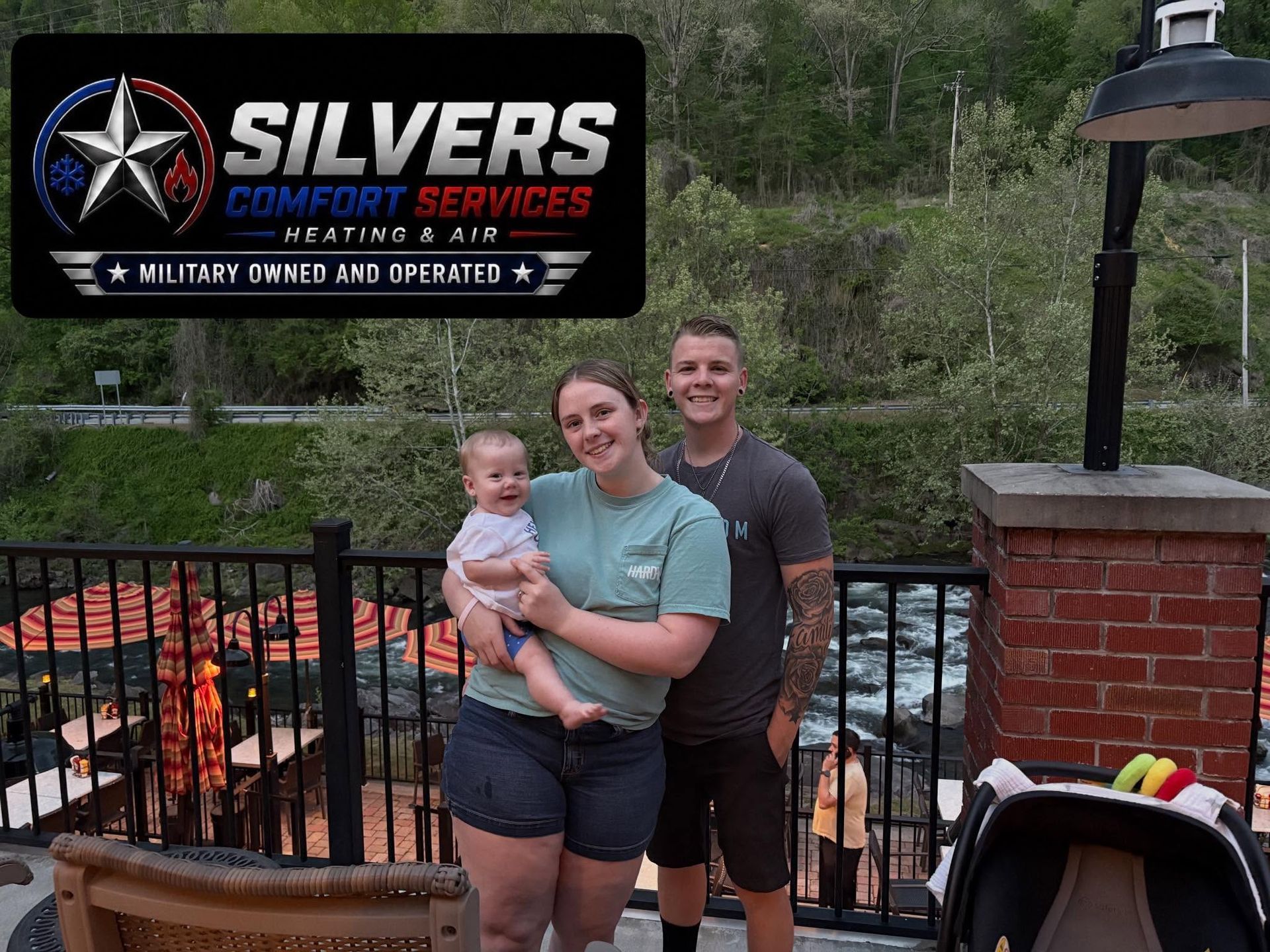 Three people posing by a fire pit and fence with a Silvers Comfort Services sign in the background