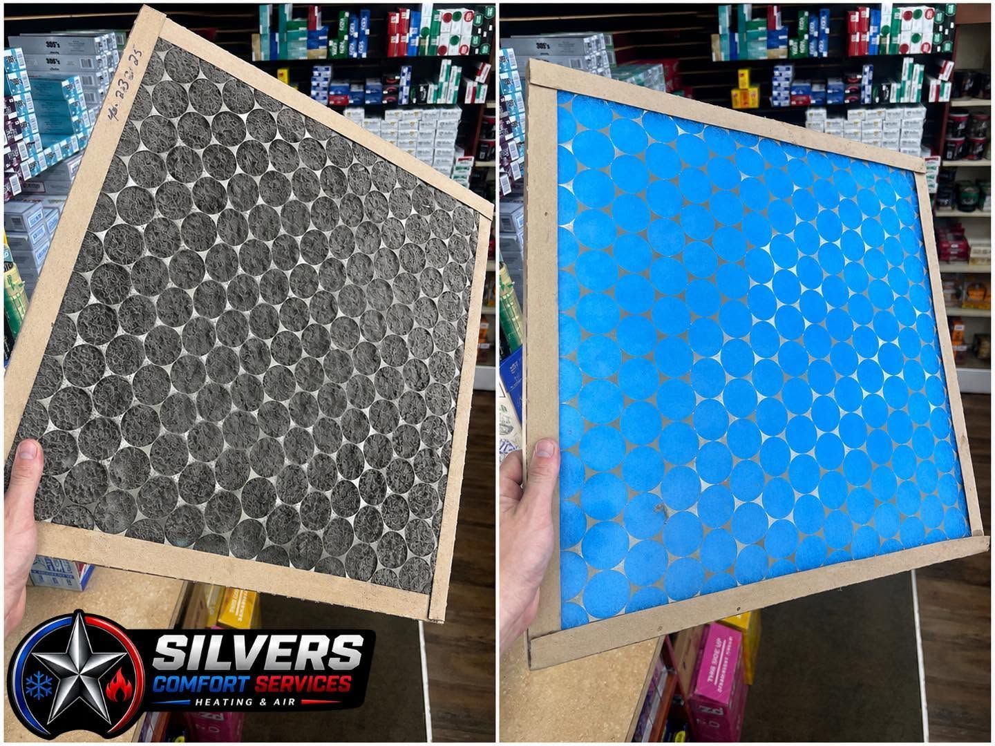 Two framed air filters, one dark gray and one blue, held up in a store aisle.