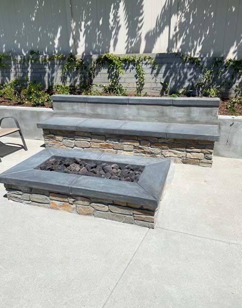 A fire pit with steps leading up to it on a patio.