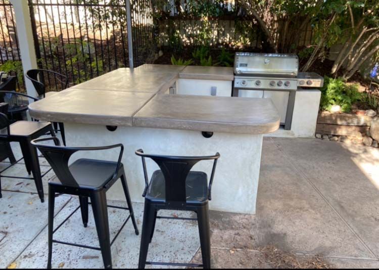 A patio with a table and chairs and a grill