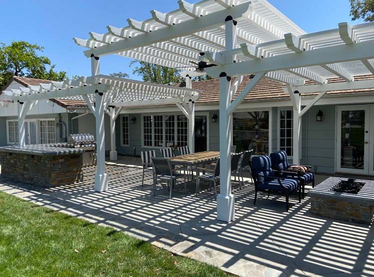 An outdoor kitchen with a fireplace and a flat screen tv.