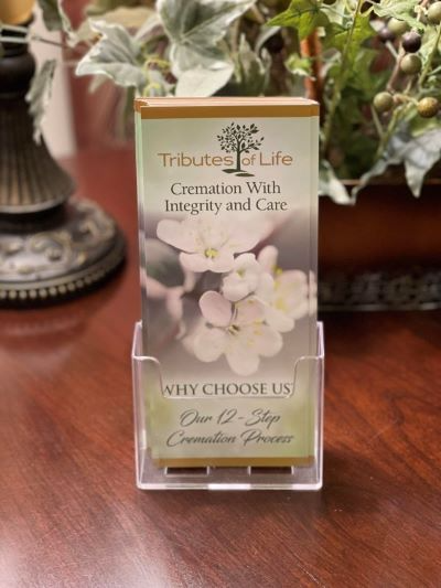Brochure in a clear holder on a wooden table. It says 