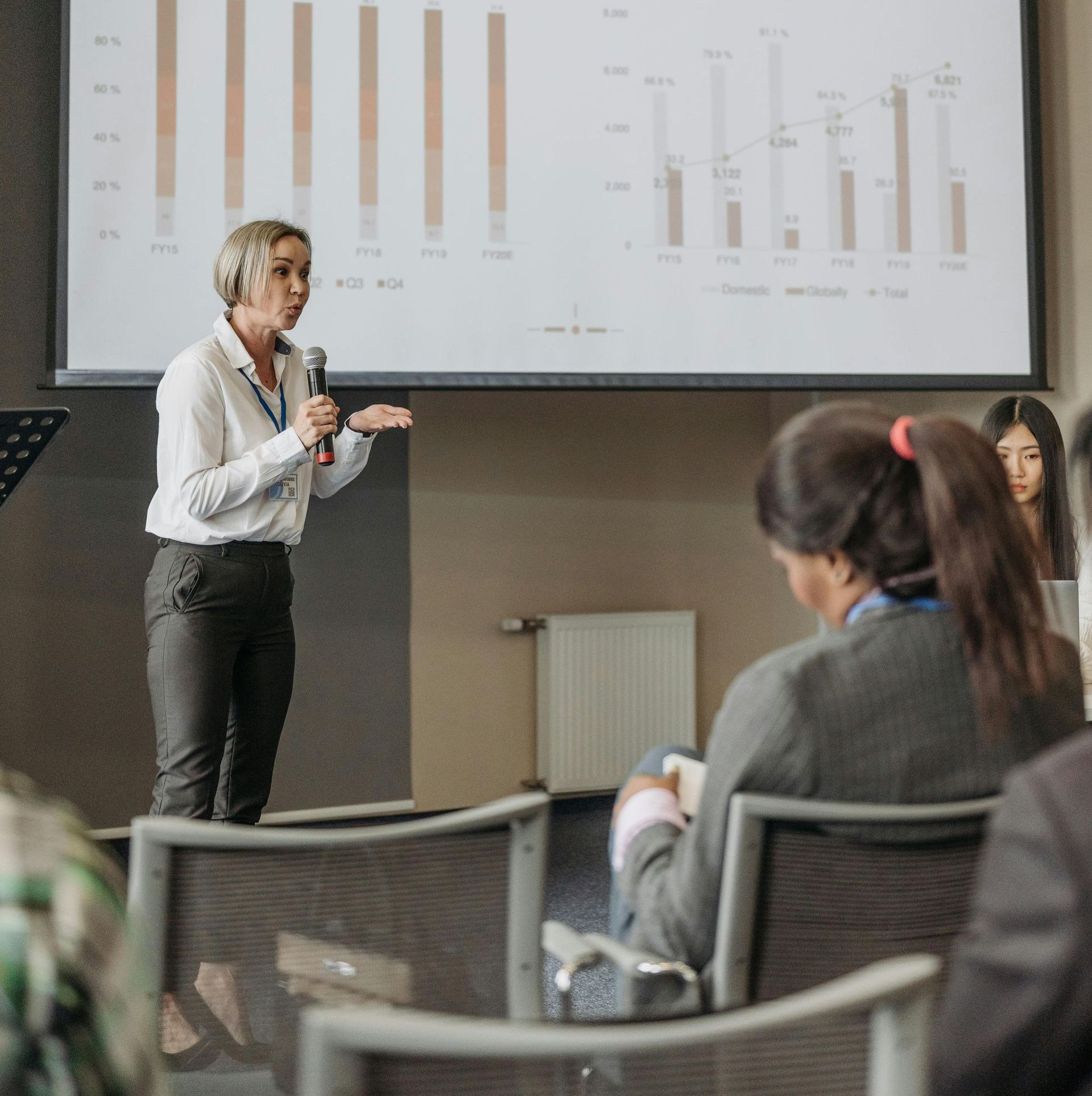 A woman is giving a presentation to a group of people