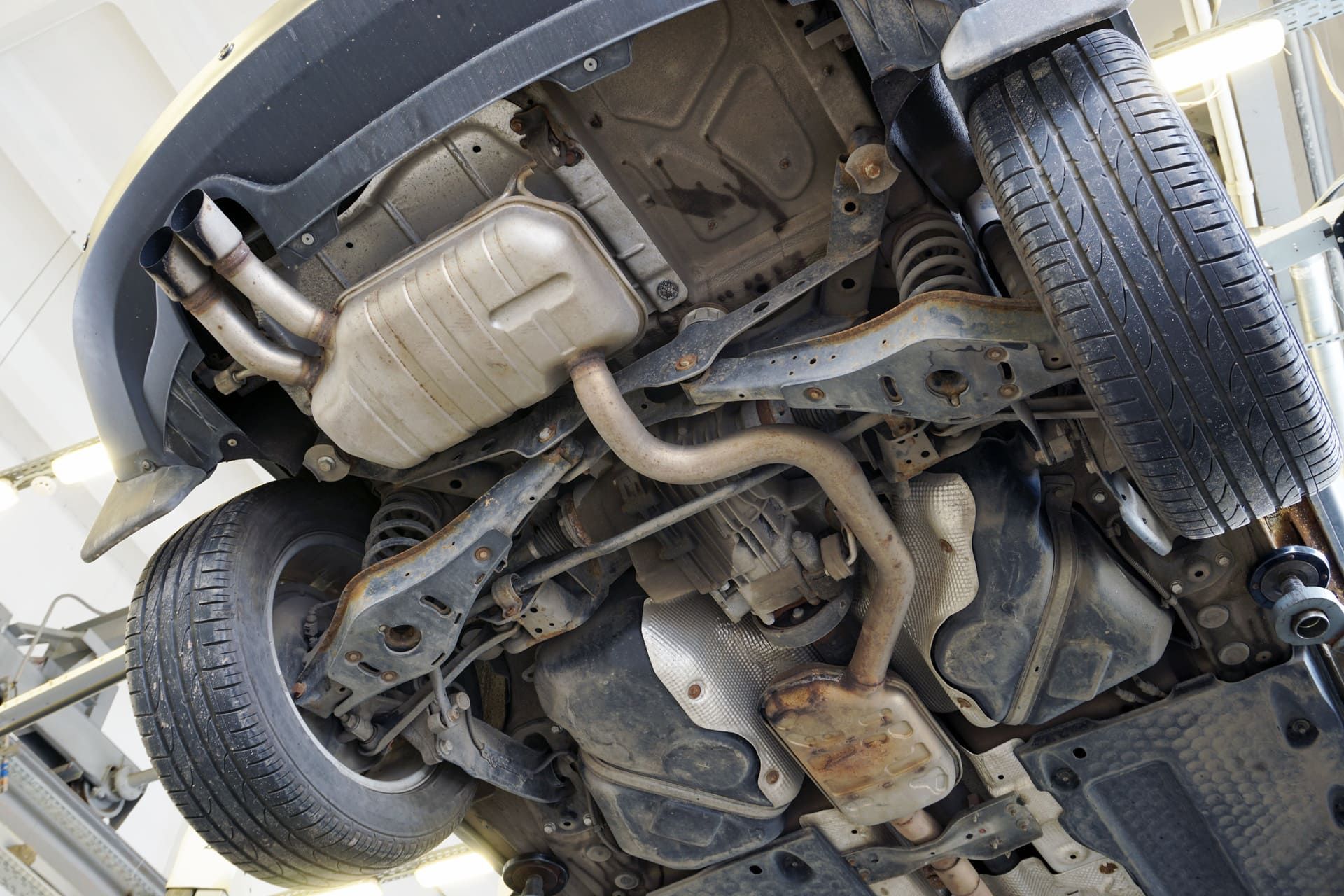 A modern powerful car in a car service on a lift. Bottom view. Details of the suspension and exhaust system are visible