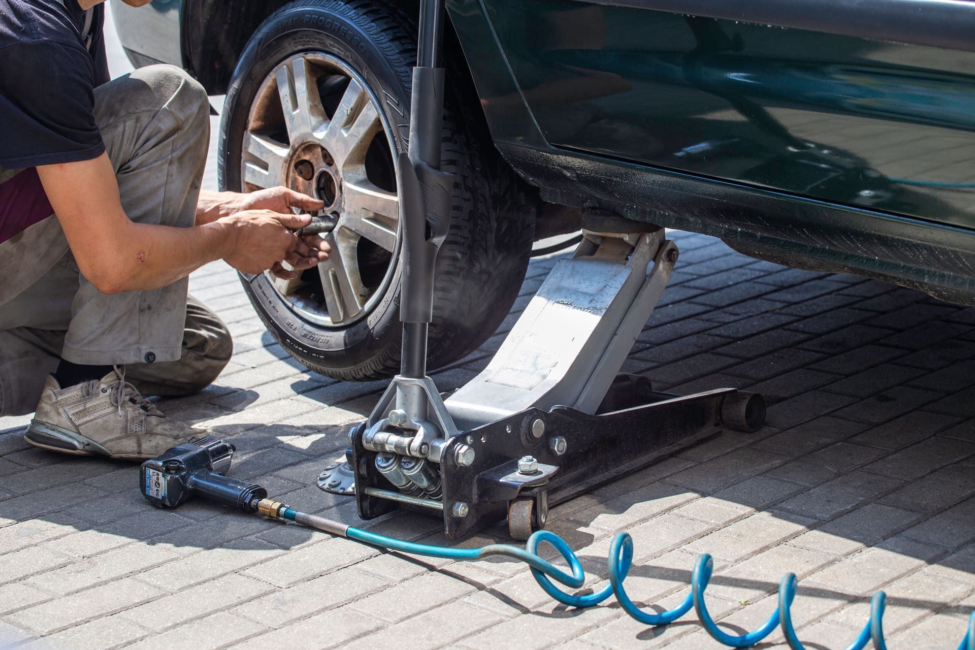 Replacing the wheel in the car. Car mechanic. Jack, bolts, car service. Vulcanization