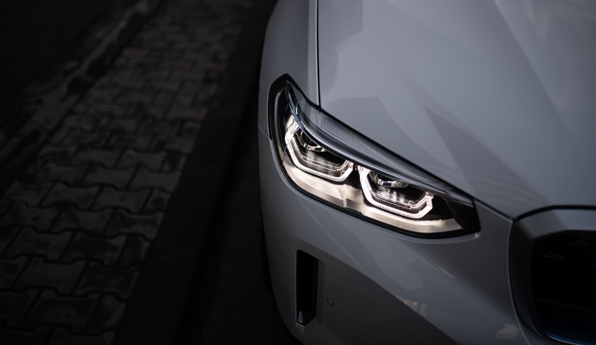 Detail close up view of the LED adaptive head light of premium luxury sedan car. Automotive headlight lighting technology detail