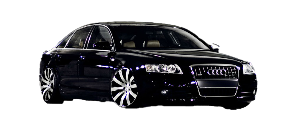 A black audi is parked in a parking lot at night.