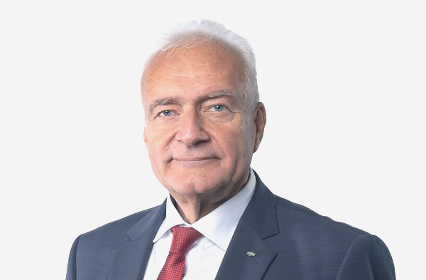Studioaufnahme eines Mannes in dunklem Anzug und roter Krawatte vor hellem Hintergrund