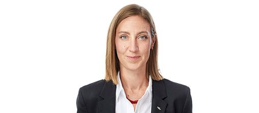 Porträt einer Person in schwarzem Blazer und weißem Hemd vor einfarbig weißem Hintergrund
