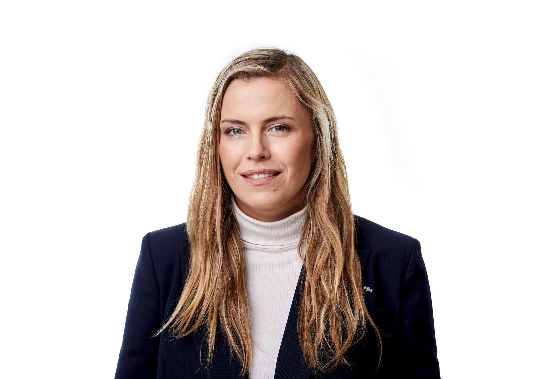 Porträt einer Person in einem dunkelblauen Blazer und einem weißen Rollkragenpullover vor weißem Hintergrund