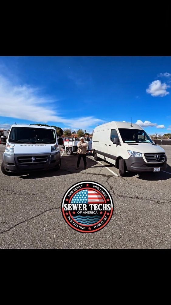 Two work vans and people standing in a parking lot under a blue sky, company logo at the bottom.