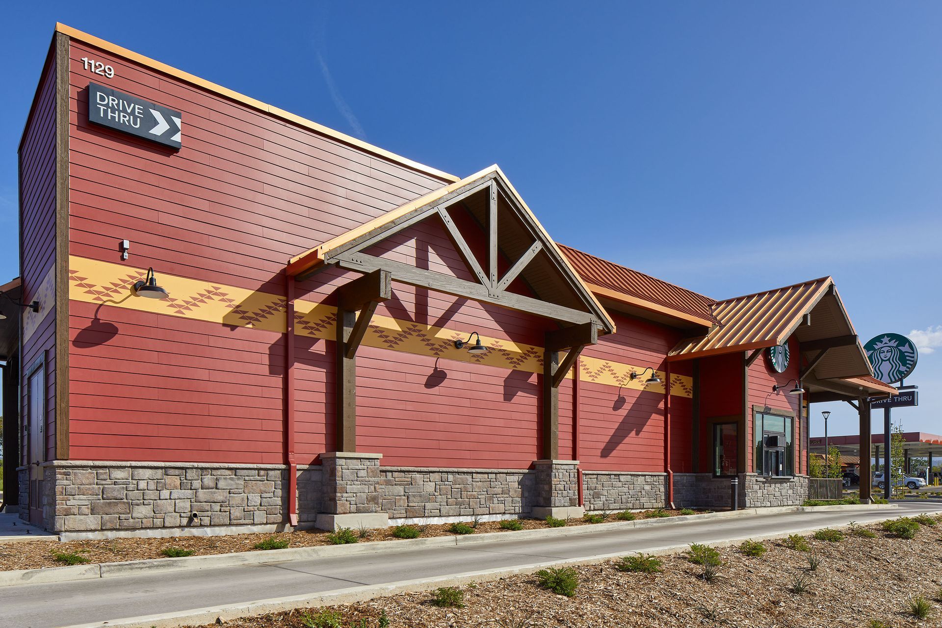 Red brick building with stone base and wooden beams under a clear blue sky