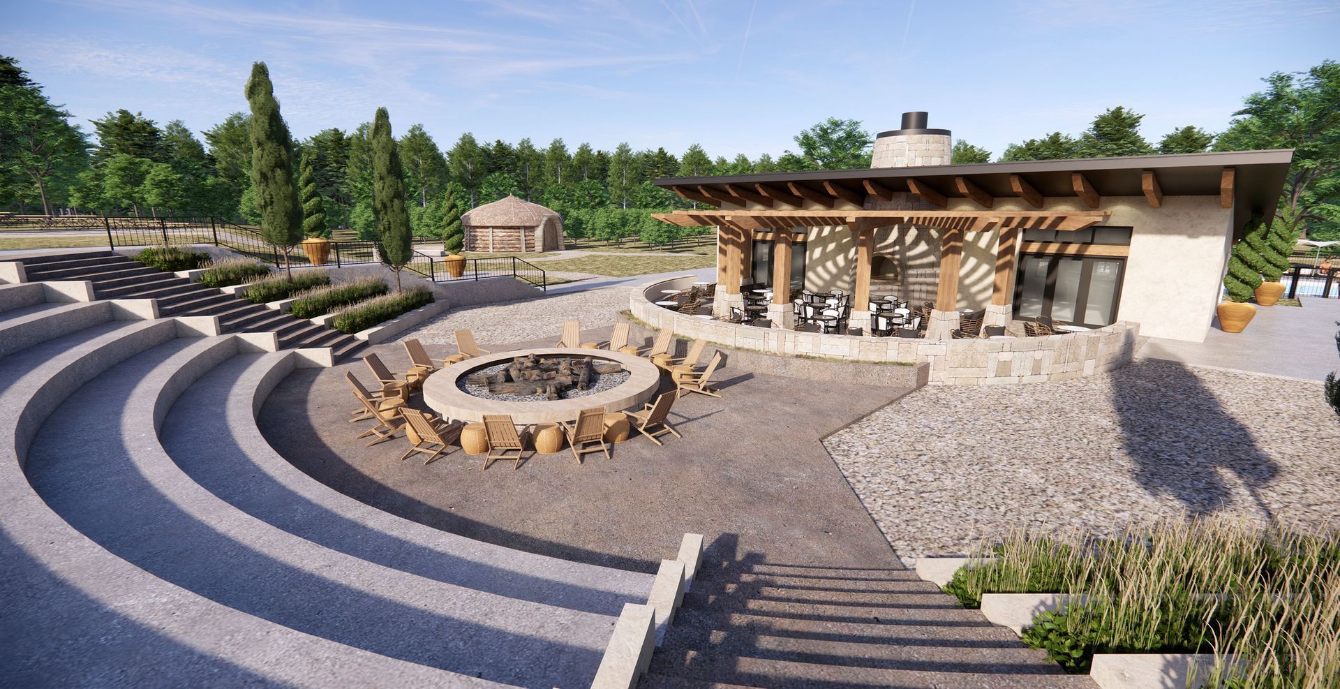Outdoor amphitheater seating overlooking a circular fire pit with lounge chairs, next to a modern stone pavilion.