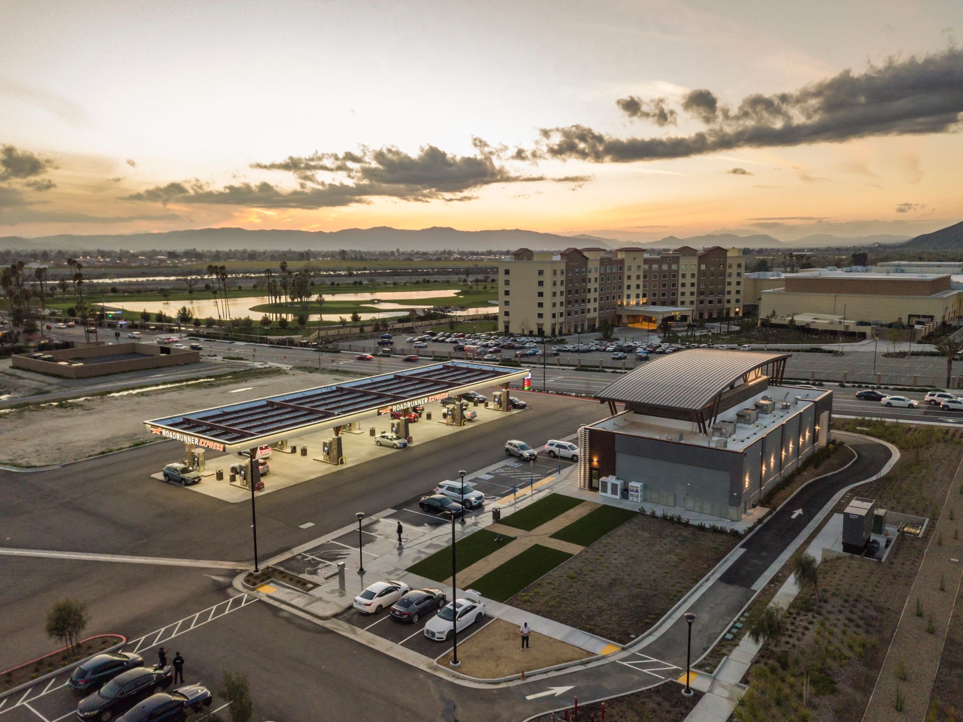 An aerial view of a parking lot with a building in the background.