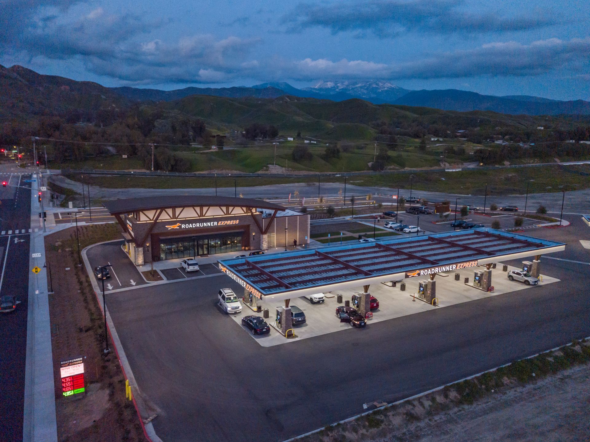 An aerial view of a gas station with solar panels on the roof.
