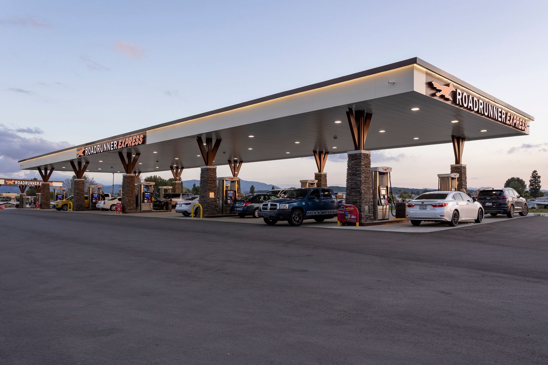 A gas station with cars parked in front of it.