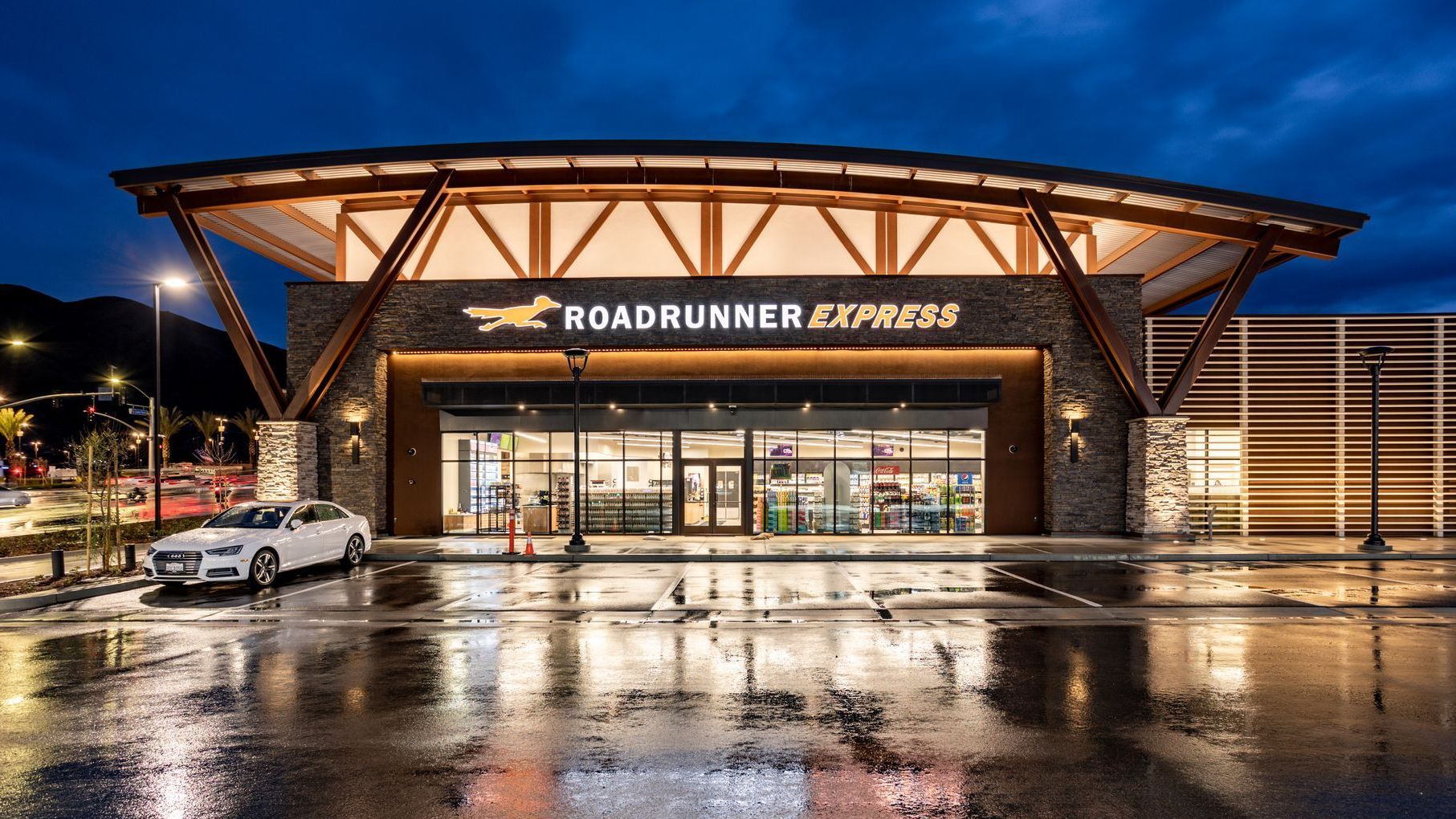 Roadrunner Express gas station at dusk, with a white car parked in front.