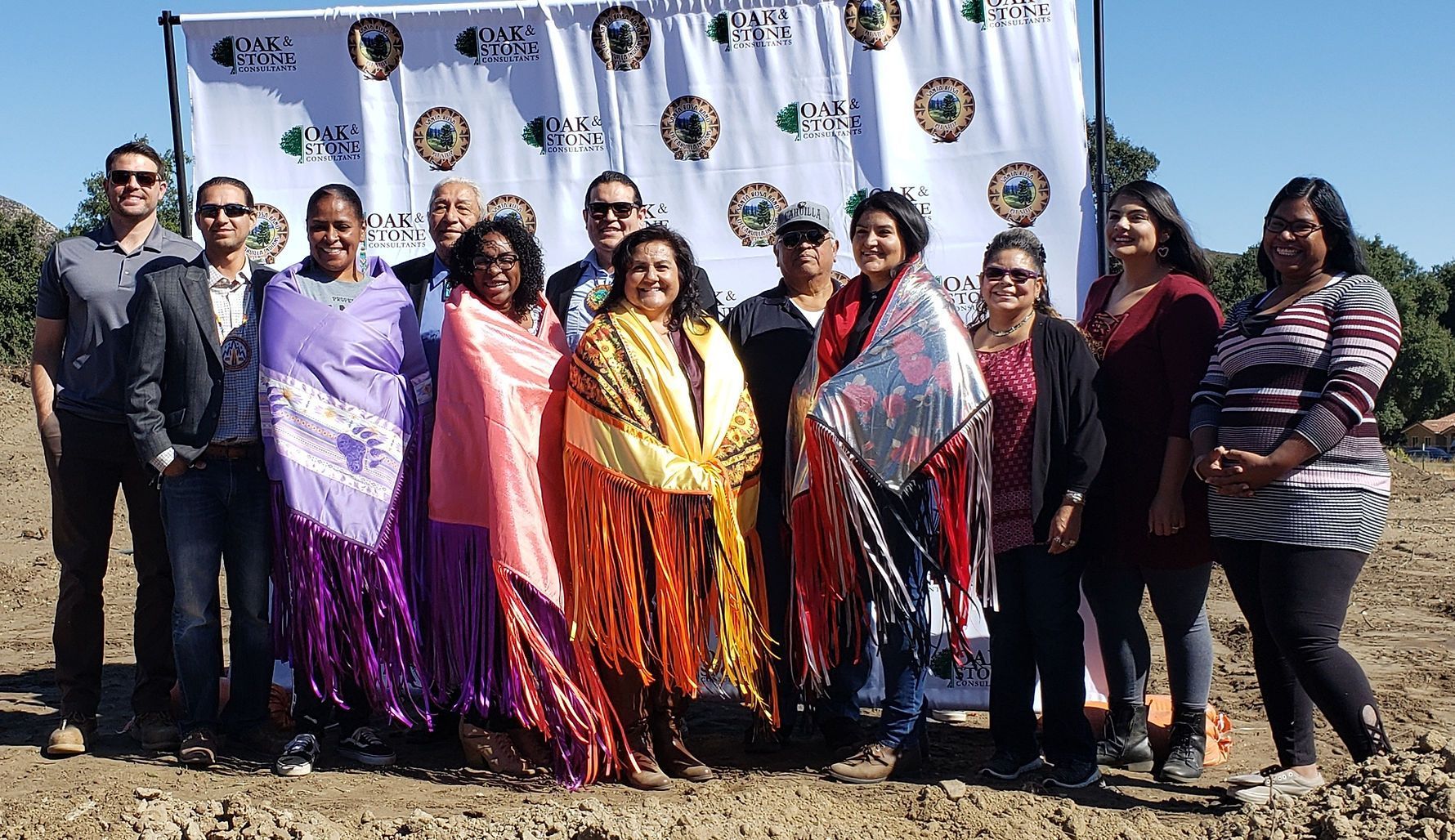 A group of people are posing for a picture in front of a banner.