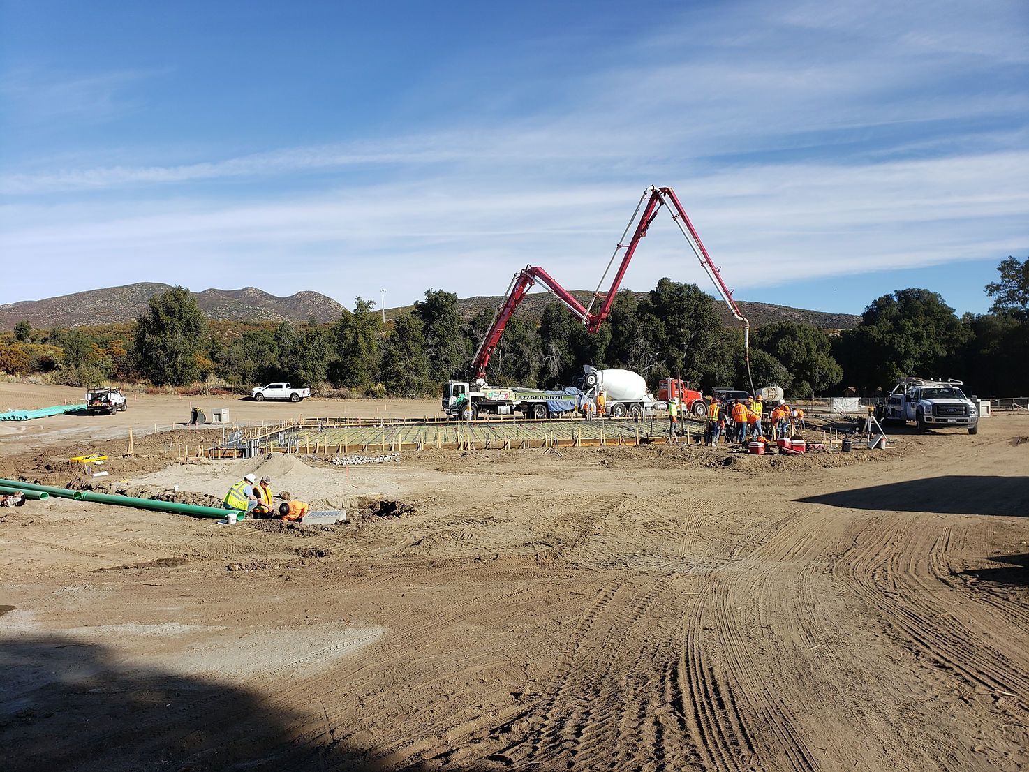 A construction site with a concrete pump in the middle of it.