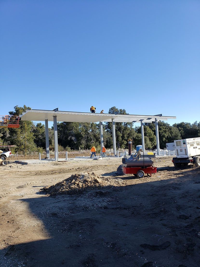 A group of construction workers are working on a gas station under construction.