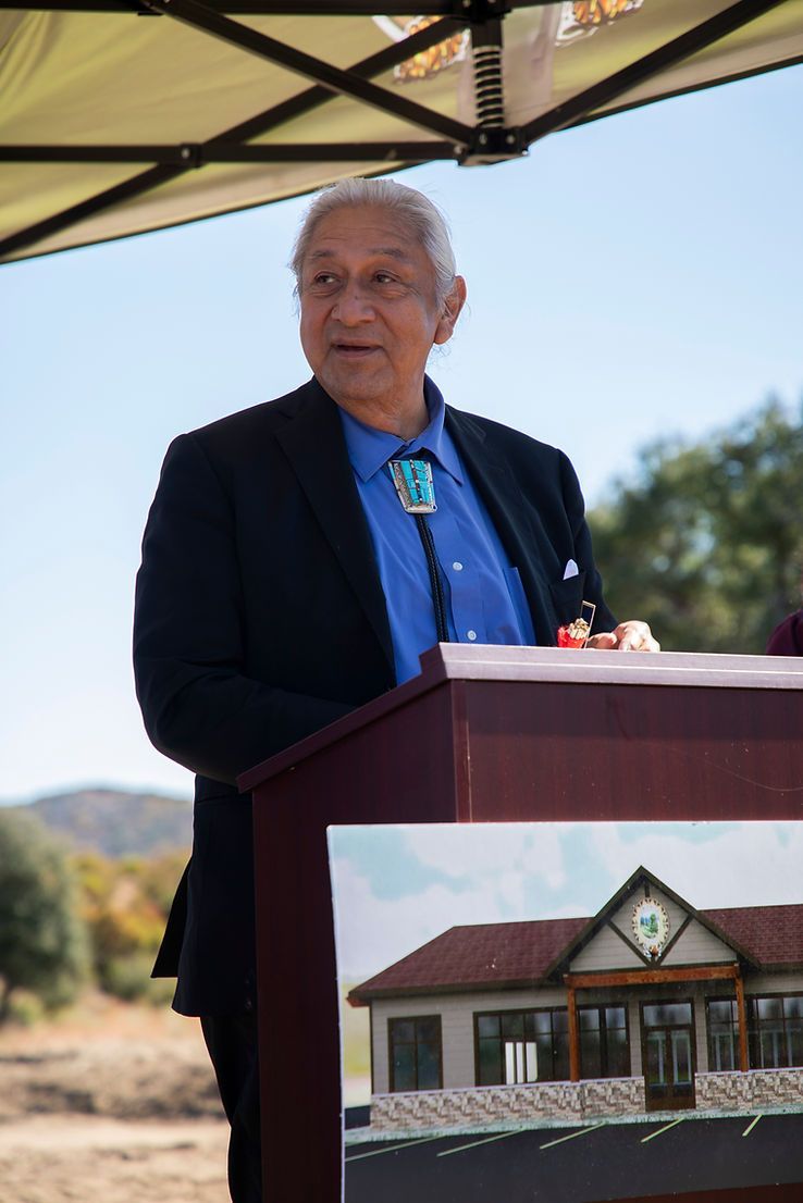 A man in a suit and tie is standing at a podium giving a speech.