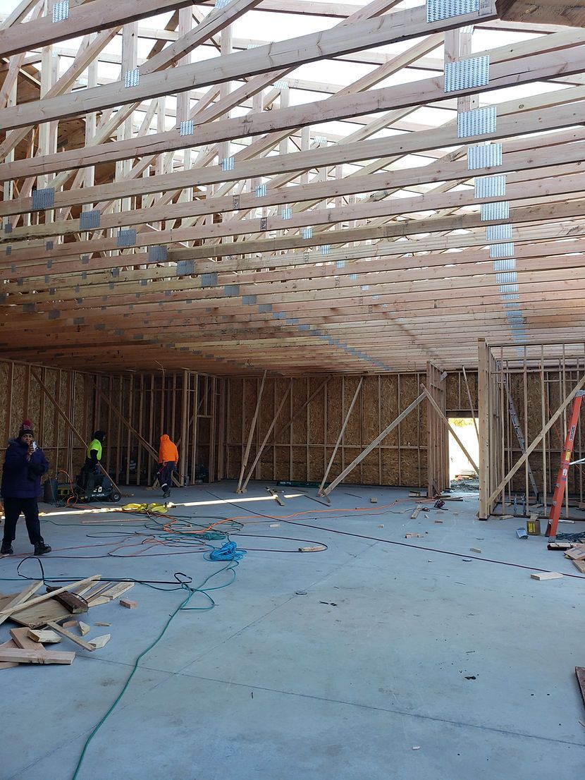 A man is standing in the middle of a building under construction.
